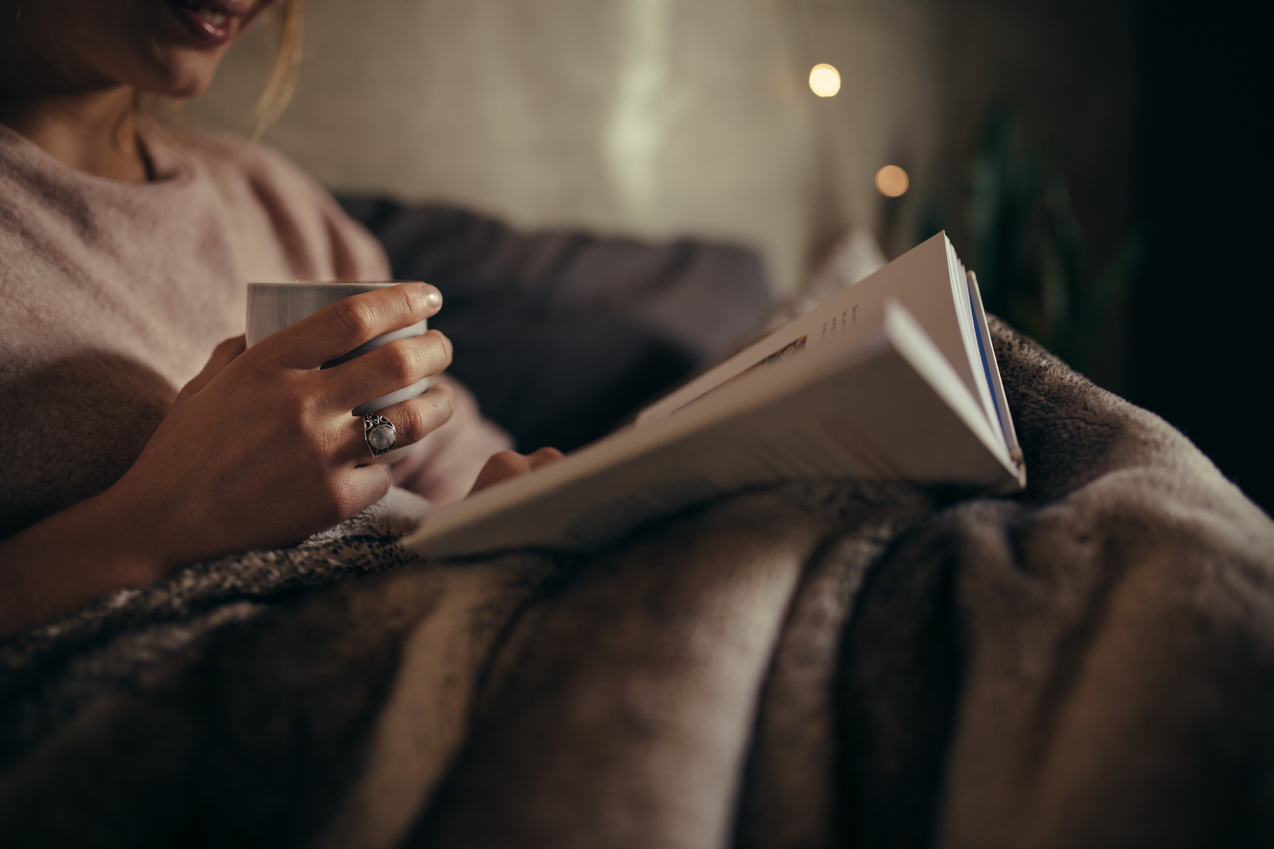 Female Reading Book on Bed at Night