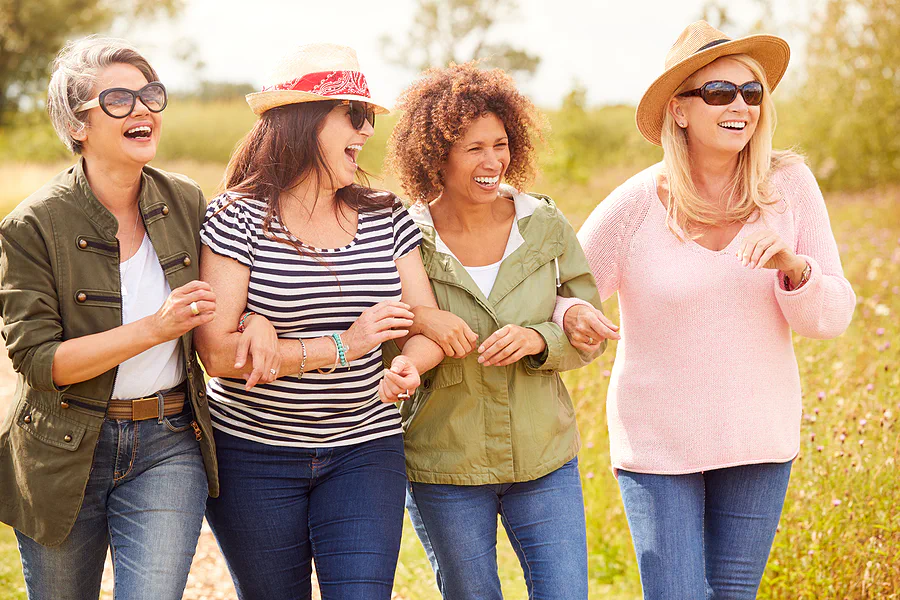 A group of mature women walking outdoors and laughing